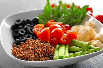 Plate with quinoa and vegetables on table, closeup