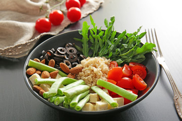 Plate with quinoa and vegetables on table