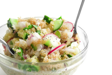 Mixing quinoa salad on white background