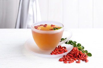 Composition with goji tea on white wooden table