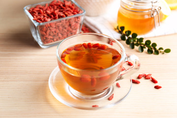 Cup of goji tea on wooden table