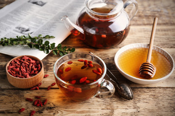 Composition with goji tea on wooden table