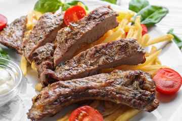 Plate with delicious grilled steak frites on kitchen table