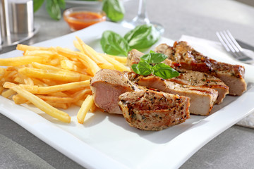 Plate with delicious grilled steak frites on kitchen table