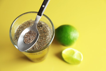Spoon and glass of water with chia seeds on table