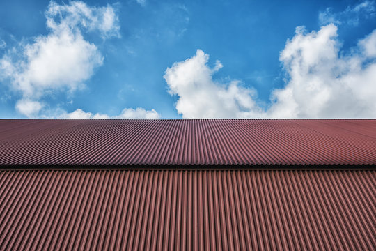 Picture of blue sky and red metallic tile roof