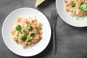 Plates with rice pilaf and broccoli on table