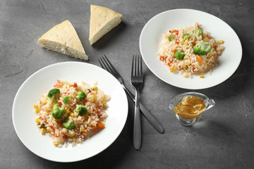 Plates with rice pilaf and broccoli on table