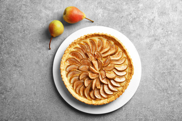 Plate with tasty pear tart on table