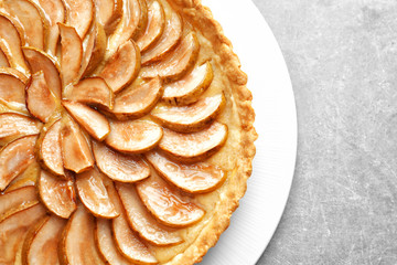 Plate with tasty pear tart on table, closeup
