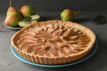 Plate with tasty pear tart on table