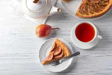 Composition with tasty pear tart on white wooden table