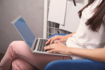 Naklejka premium Young woman with laptop at home