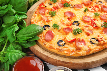 Tasty pizza with sausage on wooden board, close up