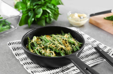 Frying pan with delicious green bean casserole on kitchen table