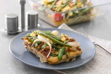 Plate with delicious green bean casserole on kitchen table