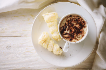 Cup of hot cocoa and cream cakes