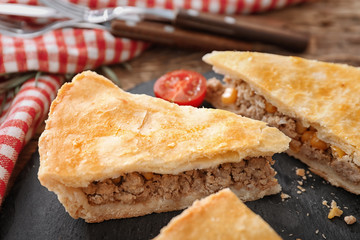 Pieces of delicious meat pie on slate plate
