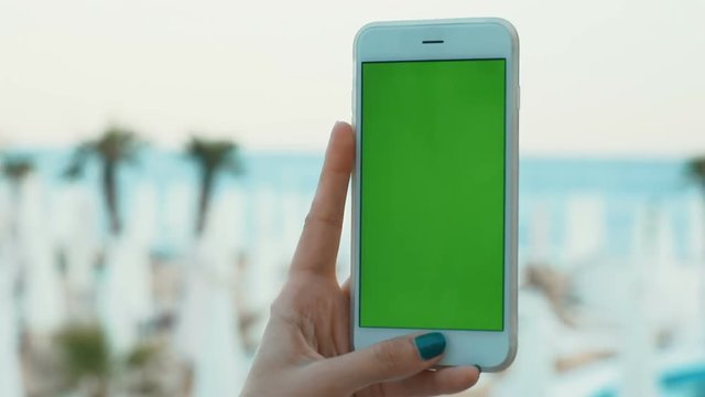 Young woman hands using mobile phone smart blank green screen sea beach horizon seaside resort vacation traveling concept pointing finger touchscreen tap close up shoot sunny day conection 3g app