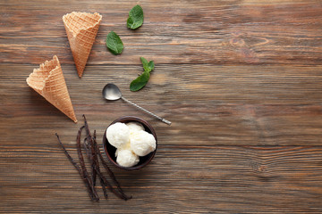 Composition with yummy vanilla ice cream on wooden table