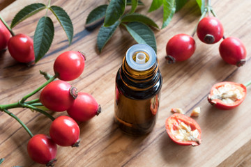 A bottle of rose hip seed oil on a wooden table