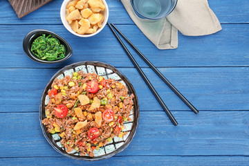 Composition with plate of brown rice on wooden table