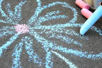 Chalk drawing of flower on asphalt, closeup