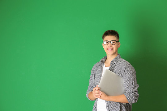 Teenager Boy With Laptop On Color Background