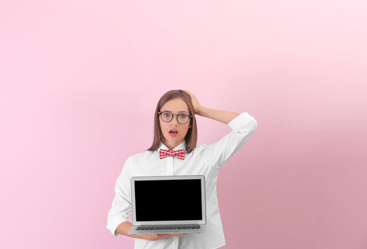 Teenager girl with laptop on color background