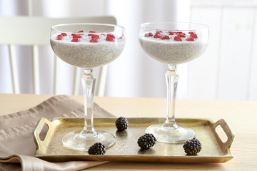 Glasses with delicious chia seed pudding on metal tray