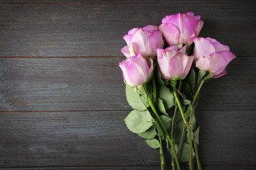 Beautiful pink roses on wooden background