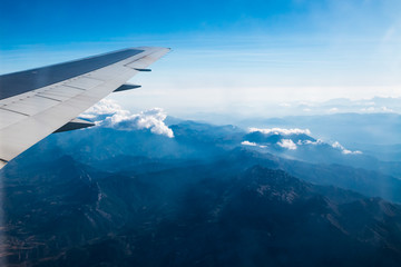 Obraz premium Wing of airplane flying above the Earth