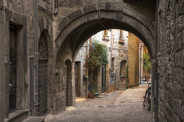 Fototapeta na wymiar Dettaglio di un arco che unisce due palazzi in uno stretto vicolo medievale. Questa via si trova nel centro storico di Viterbo e precisamente nel quartiere San Pellegrino.