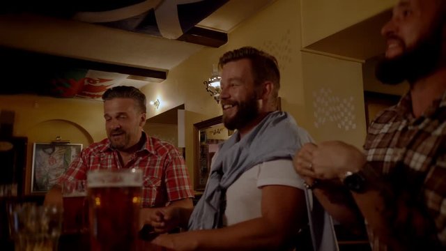 Good old friends drinking beer in a pub