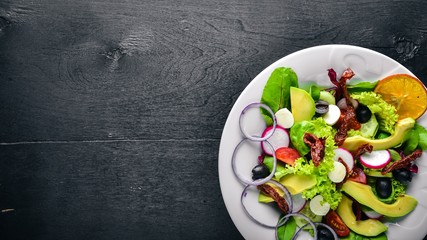 Avocado Salad with grilled meat and greens. Italian cuisine. Top view. On Wooden background.