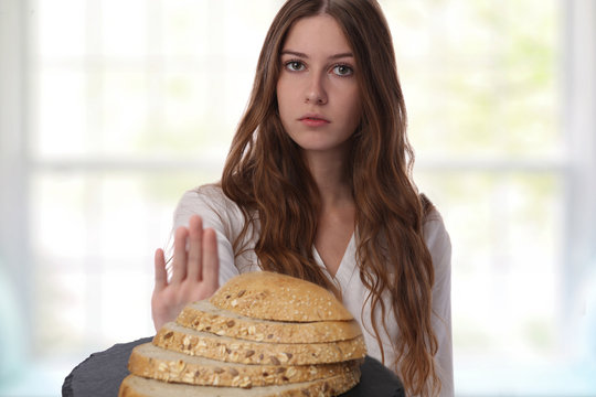 Gluten Intolerance And Diet Concept. Teenage Girl Refuses To Eat White Bread.