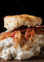 Buttermilk biscuit and fried chicken breast sandwich with a fried egg and bacon