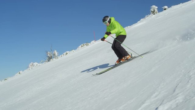 TRACKING SLOW MOTION Following recreational skier who enjoys idyllic perfect weather on a cold excellent winter day at mountain top with sunny weather above the fog with Alps in the background