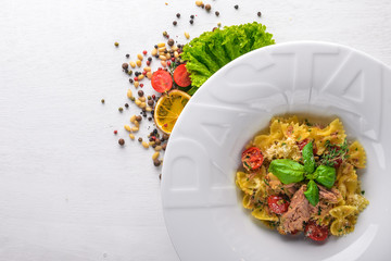 Pasta with tomatoes and basil. Plate with the word 
