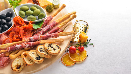 Cold snacks. Chopped sausage, bacon, olives, olives. Top view. Wooden background. Free space for text.