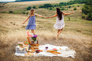Beautiful young girls girlfriends on a picnic on a summer day. The concept of leisure, privacy,...