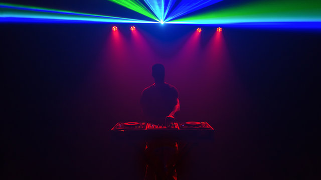 Male Disc jockey, DJ, silhouette with laser light