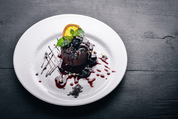 Chocolate dessert. Baking with ice cream. Top view. Free space for text. On a wooden background.