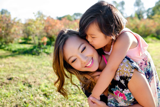 Happy Asian mother and daughter in a park