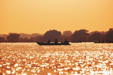 Landscape at sunset of boats with fishermen fishing on Pantanal
