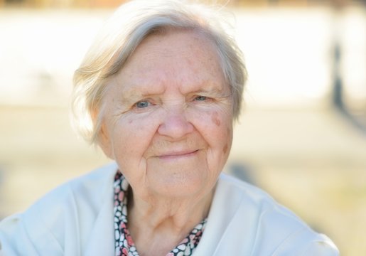 Senior woman smiling and dreaming in garden.