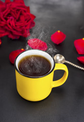 round yellow mug with hot tea on a black table