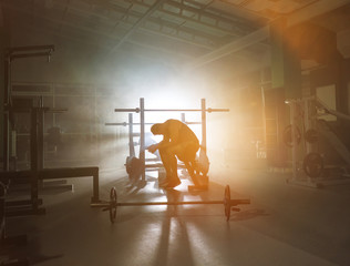 The tired man sit in the fitness center on the background of the smoke
