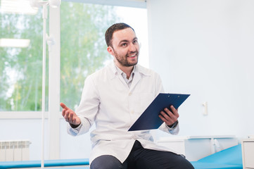 Portrait of handsome young doctor in office