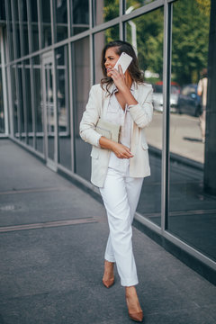 Series of a business woman in the city. Beautiful brunette sitting in coffee shop and working on com